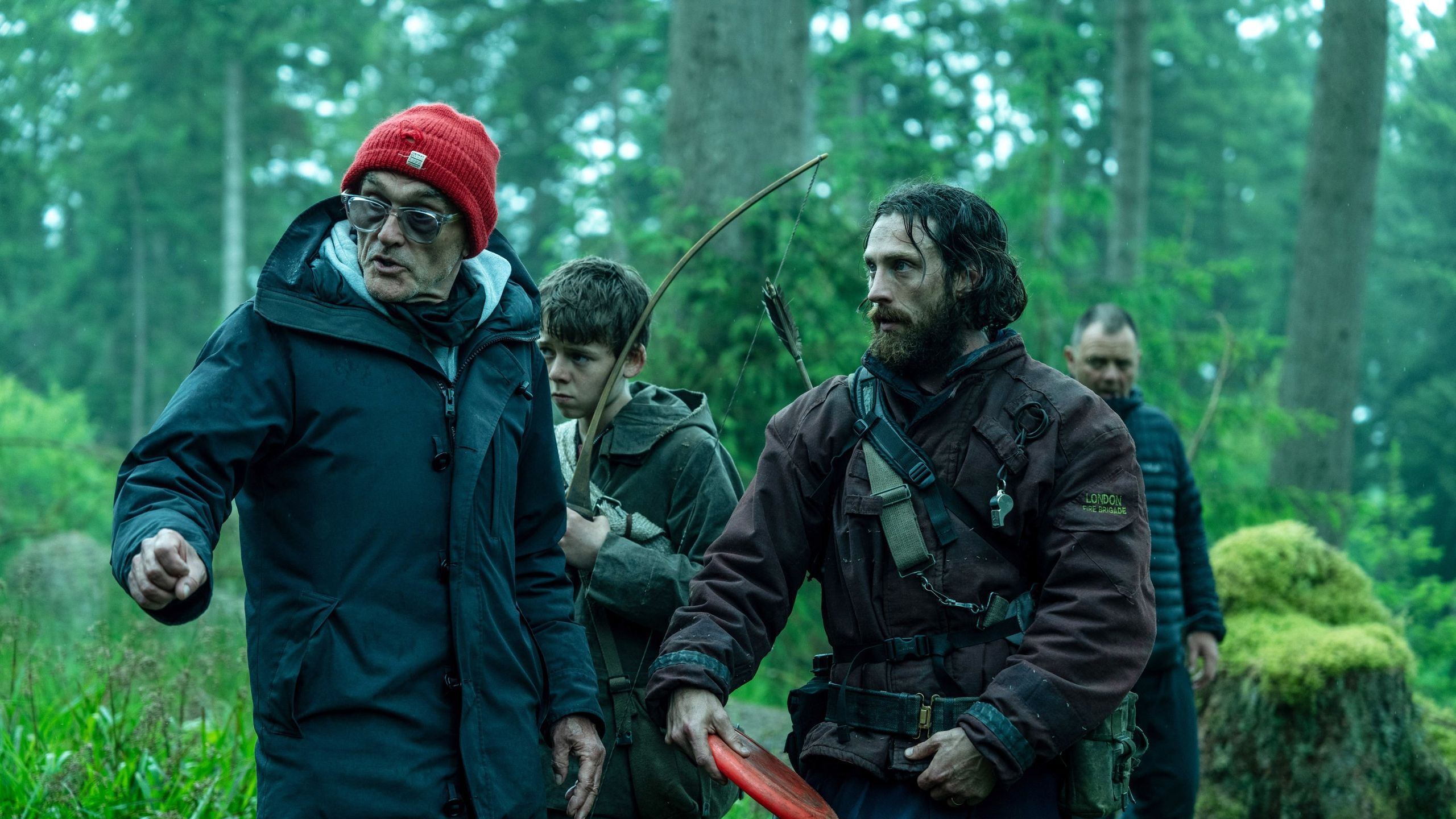 Danny Boyle with Alfie Williams and Aaron Taylor-Johnson in a wooded location on the set of 28 Years Later.
